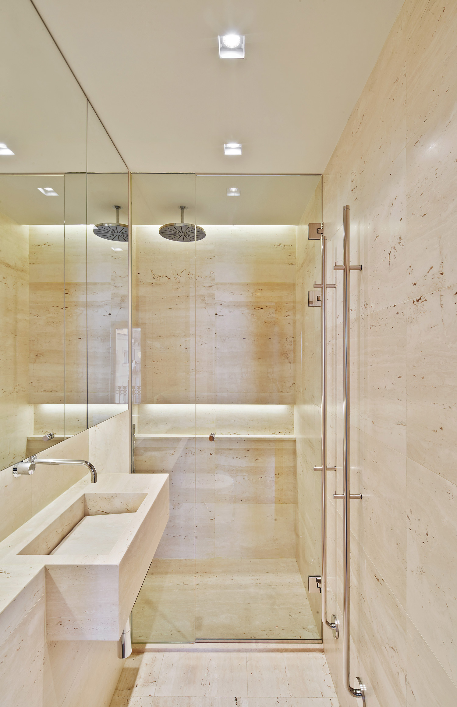 Barcelona apartment renovation with travertine stone bathroom and mirror cabinets
